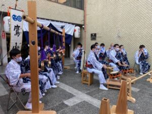 Japanese men play musical instruments while wearing cotton kimono and masks during covid.